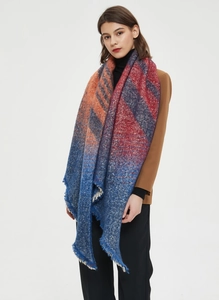 Detailed close-up showing the soft plaid texture and fringe edges of the winter shawl