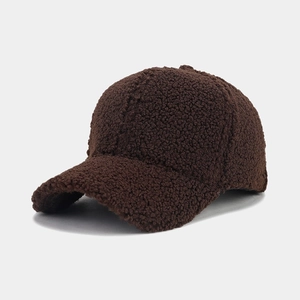 Detailed texture of thick dark brown lamb wool fabric on a curved brim baseball cap