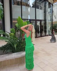 Détail d'une robe sans manches vert vif avec des textures en maille à franges étagées