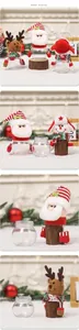 Detail of Christmas candy jars with Santa, Snowman and Deer plush figures on clear bases