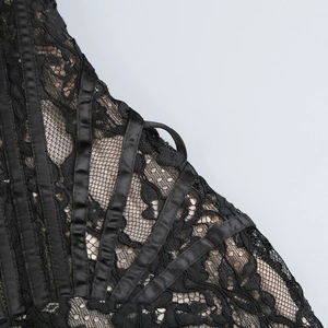 Gros plan de la dentelle noire avec ruban et doublure en maille beige sur la robe