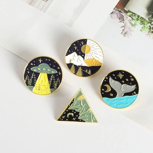 Set of four enamel pins featuring whale tail and nature motifs on white card