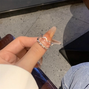Close-up of a silver twist wave ring with sparkling zircons worn on the index finger