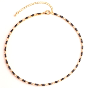 Detail of gold necklace featuring alternating black rectangular and clear round zircons
