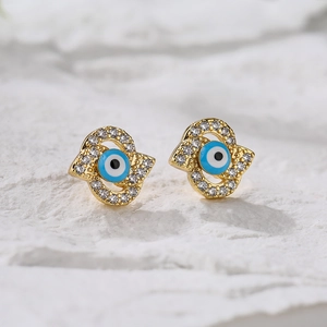 18K gold plated evil eye earrings with zircon inlay on a white textured surface