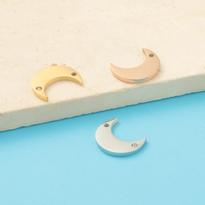 Detailed view of crescent moon pendants with crystals in gold, rose gold and silver