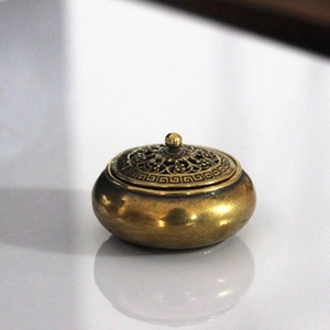Dettaglio di un bruciatore di incenso in ottone vintage con motivi floreali sul coperchio