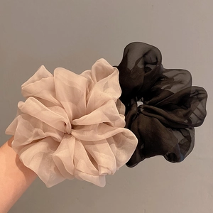 Detailed macro view of large sheer organza scrunchies in beige and black colors