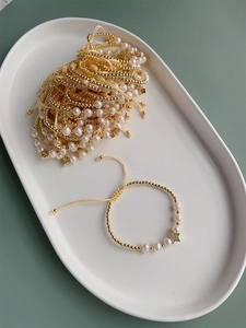 Freshwater pearl bracelet with gold beads and star charm on a beige woven rope