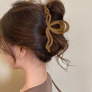 Dettaglio di una pinza per capelli marrone opaca a onde per uno chignon chic
