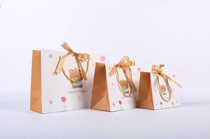 Three sizes of khaki cartoon bear gift bags with gold silk ribbon handles and bows