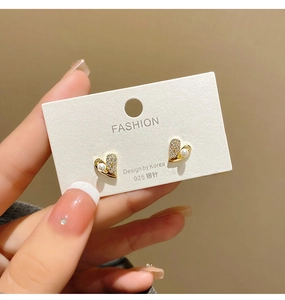 Detailed view of heart stud earrings with white pearl and micro-pave cubic zirconia