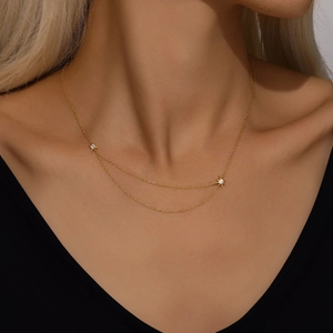 Close-up of double-layer gold star pendant necklace featuring sparkling zircon accents