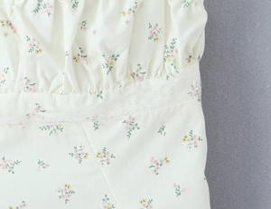 Detailopname van bloemenprint stof met witte kantafwerking en geplooide details voor dames