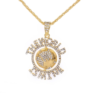 Gros plan détaillé du collier planète doré avec strass et texte The World Is Mine