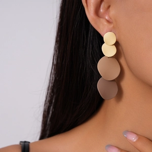 Detail of gradient geometric round earrings with matte finish on female model