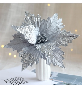 Macro shot of silver sequined Christmas poinsettia flower in a vase for festive decor