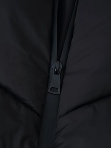 Detail of premium zipper closure and windproof texture on a black puffer jacket