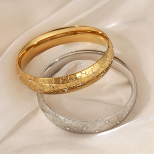 Engraved stainless steel bangle set with zircon inlay on luxury satin background
