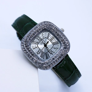 Detail of luxury square watch with diamond bezel, green leather strap and Roman numerals