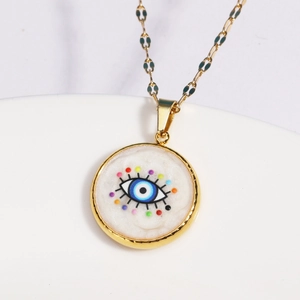 Gold evil eye necklace with colorful dots on ceramic plate, stainless steel jewelry piece