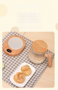 Detail of wood grain heating coaster with glass teapot showing volume markings