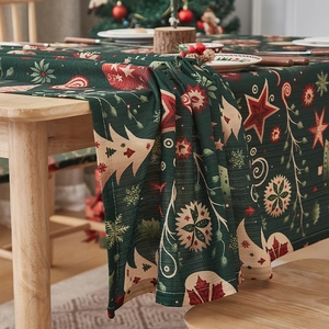 Close-up of dark green Christmas tablecloth with red stars and festive pine tree patterns