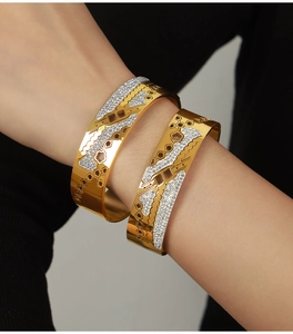 Detailed view of 18K gold plated bangle with hollow flower patterns and sparkling crystals