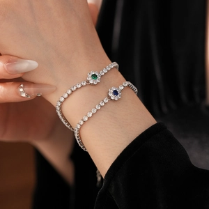 Detailed close-up of sparkling flower tennis bracelets with green and blue zircon gems