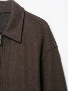 Gros plan détaillé de la texture d'une veste en laine marron foncé avec col et zip