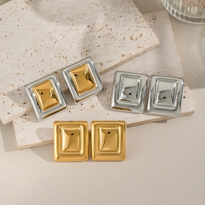 Three pairs of square geometric stud earrings in gold and silver finishes on stone