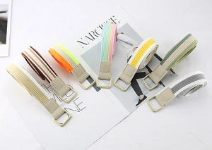 Close-up of colorful striped canvas belts with square buckles on fashion magazine