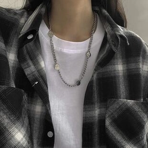 Silver chain necklace with multiple smiley face pendants shown on a checkered shirt
