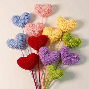 Close-up of colorful handmade knitted heart bouquets with detailed yarn texture and vibrant colors