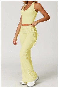 Close-up of pale yellow yoga set featuring halter neck top and side drawstring flare pants