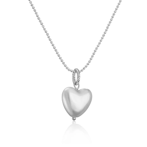 Detail of silver heart pendant with pearl chain reflecting on white background