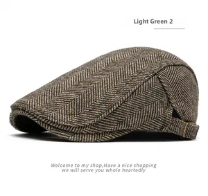 Detail of light green herringbone tweed newsboy cap with metal buckle side view