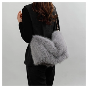 Detailed view of gray faux fur shoulder bag with gold chain strap on model