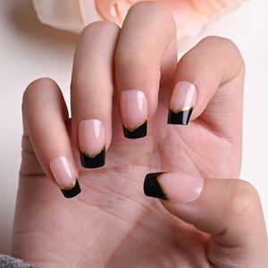 Detail of long coffin nails with pink base, black V-shaped French tips and gold glitter