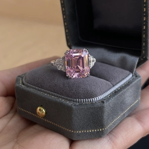 Sparkling emerald cut pink zircon ring with side stones in a velvet jewelry box