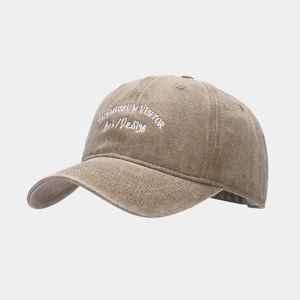 Detailed close-up of white letter embroidery on a washed cotton vintage baseball cap