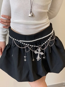 Détail d'une chaîne de taille multicouche avec perles et pendentif croix