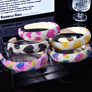 Padded rhinestone headbands with heart patterns in pink, black, and yellow colors