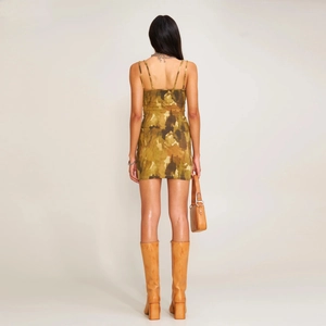 Vue arrière d'une robe mini camouflage moulante avec des bottes hautes en cuir