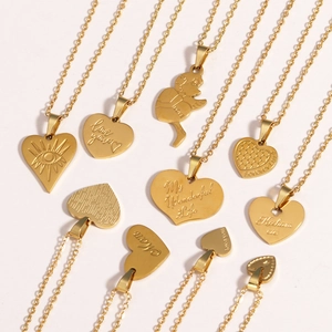 Detailed flat lay of gold titanium steel heart necklaces with assorted engraved pendants