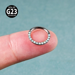 G23 titanium nose ring with opal inlay, shown on finger to demonstrate the actual size