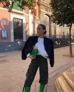 Outdoor street style view of woman wearing navy stand collar jacket with cargo pants