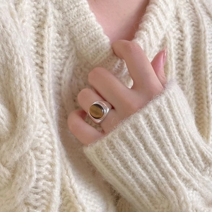 Macro shot of a vintage 925 silver ring with oval tiger eye stone on a cozy knit sweater