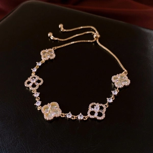 Adjustable gold flower bracelet with mother of pearl and zircon stones on black leather