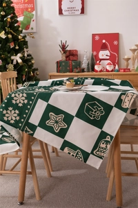 Close-up of green and white checkered Christmas tablecloth with festive ornaments and patterns